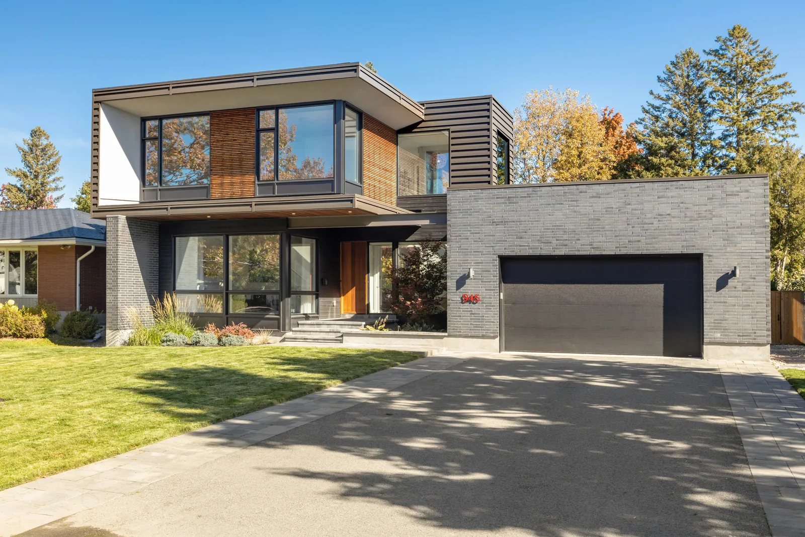 Finished residential home exterior with painted siding, trim, garage doors, and entry details.